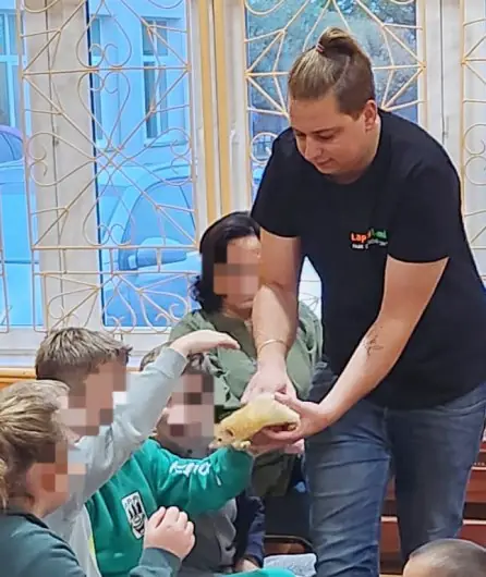 Opiekunka prezentująca zwierzęta dzieciom podczas lekcji w szkole