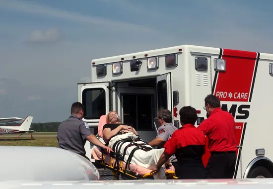 Pacjent na noszach wsuwany do ambulansu